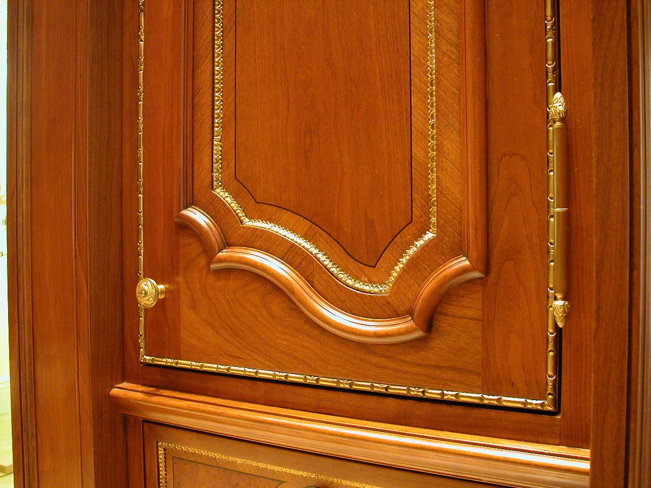 Ornamental metal hardware integrated into an elaborately crafted wood door panel.