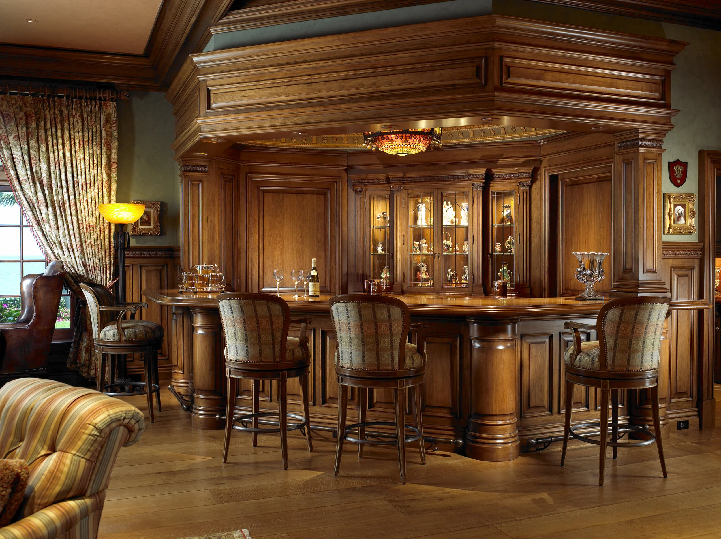 Custom wood-paneled bar and architectural cabinetry in a completed private interior.