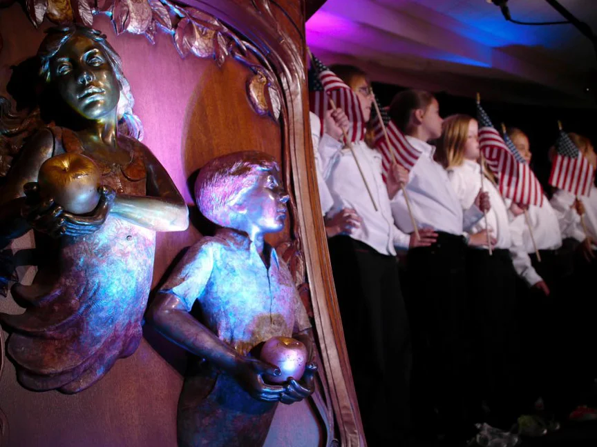 Bronze sculpture beside participants gathered for a community event.